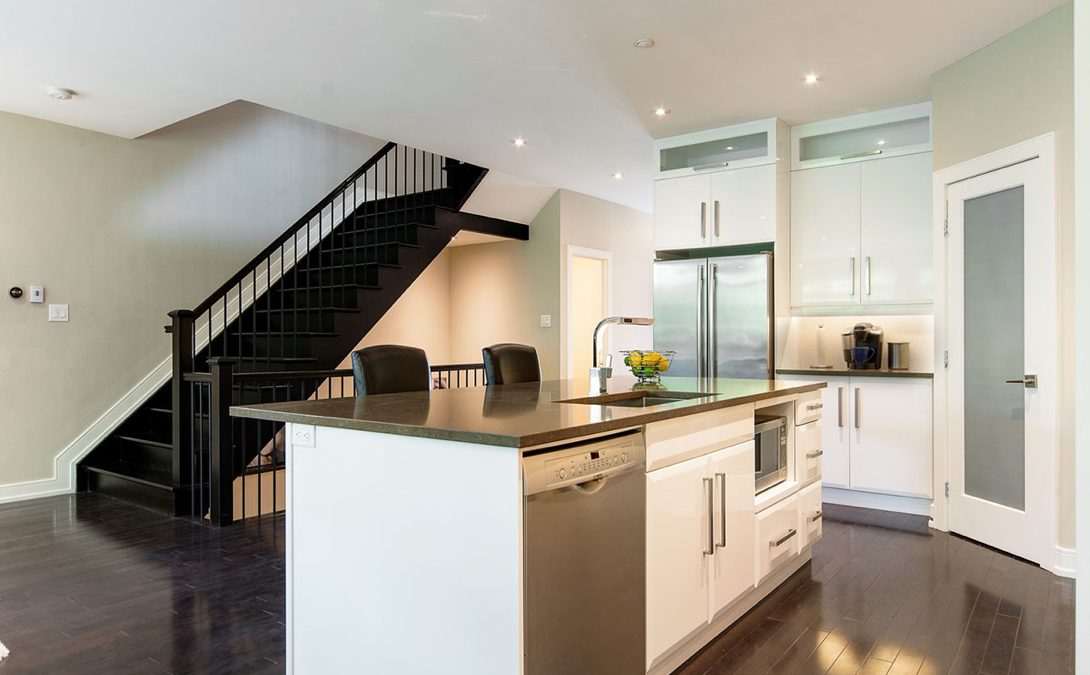 modern and sleekly designed kitchen with large island with dark coutnertops