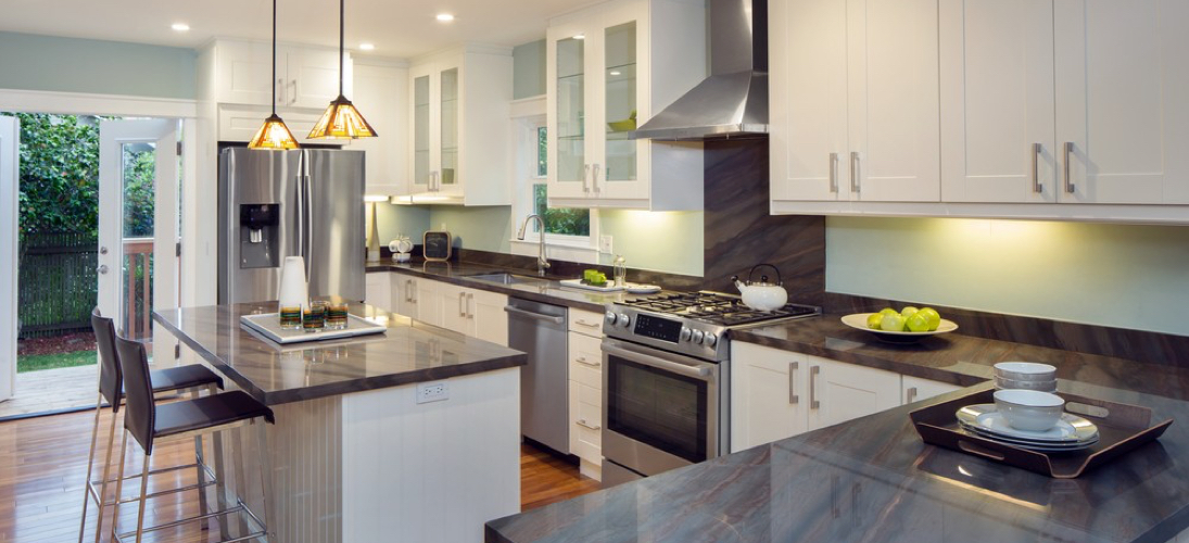 modern kitchen with white cabinetry, dark countertops and stainless steel appliances